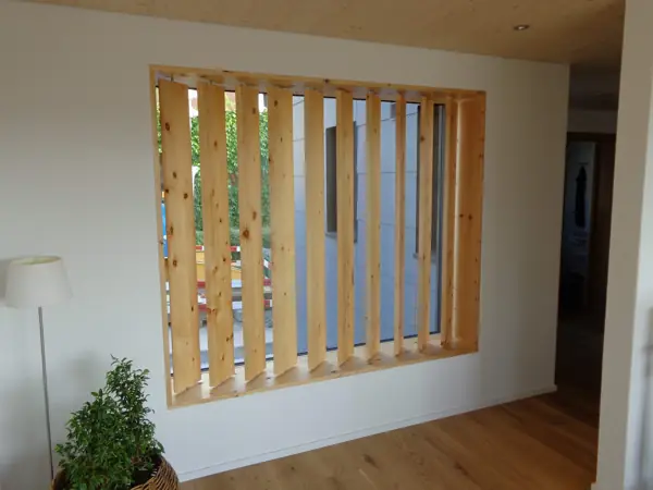 Raumtrenner aus Holzlamellen in einem hellen Wohnraum